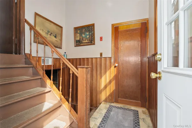 a view of staircase with lots of frames on wall and a window