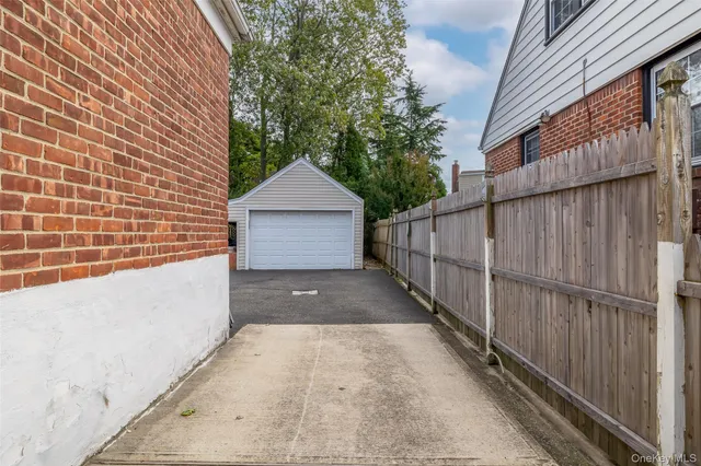 a view of terrace with wooden fence and large trees