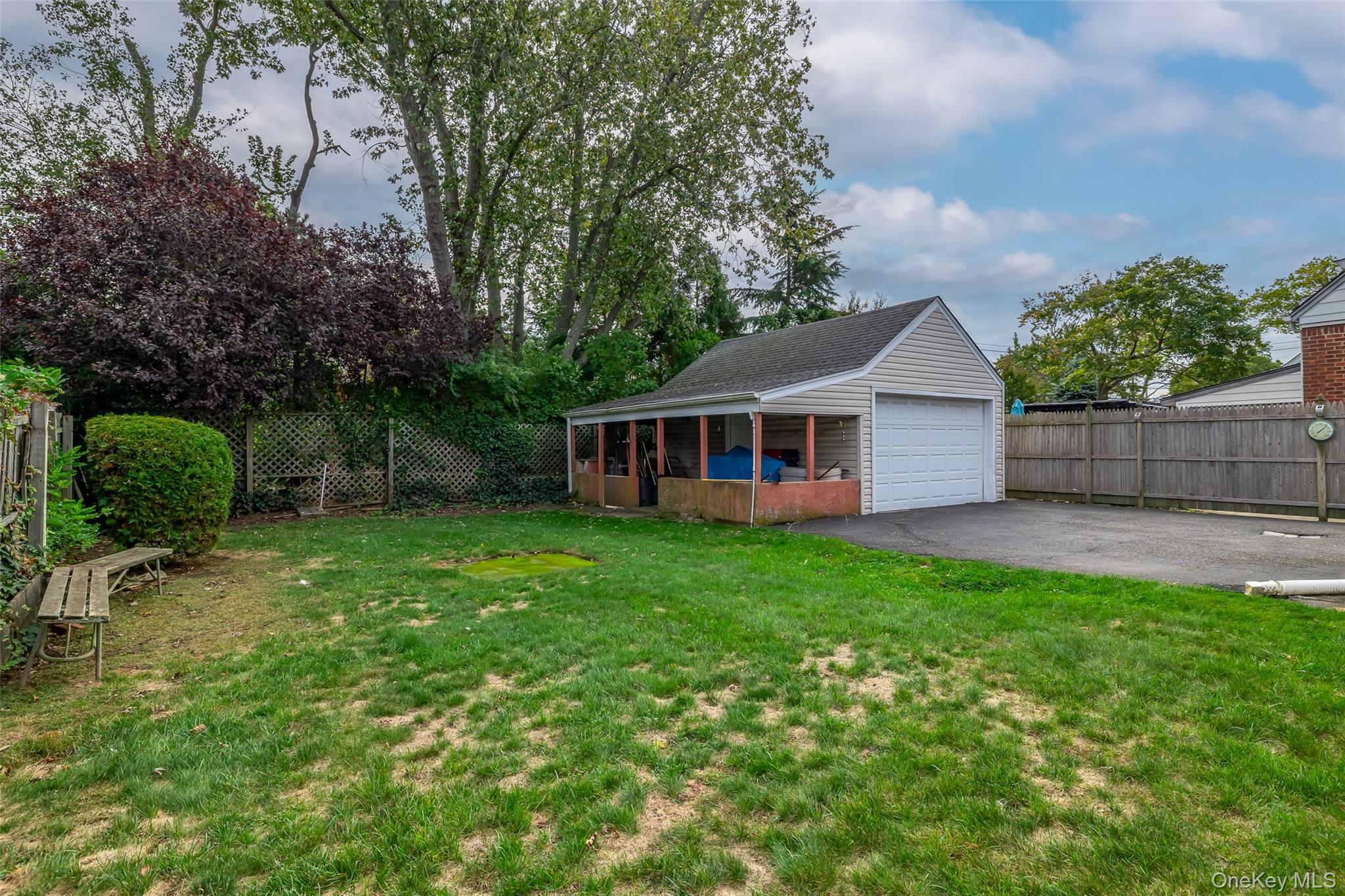 2975 Oceanside Road Oceanside, NY 11572 - Photo 23 of 26 a view of a yard in front of a house with plants and large tree