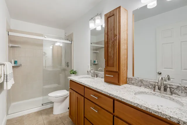 a bathroom with a granite countertop sink toilet and shower