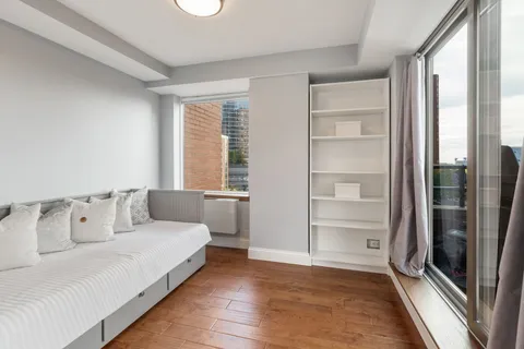 a bedroom with a bed and a large window