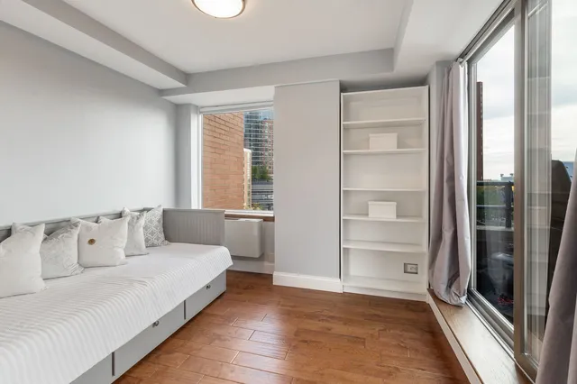 a bedroom with a bed and a large window