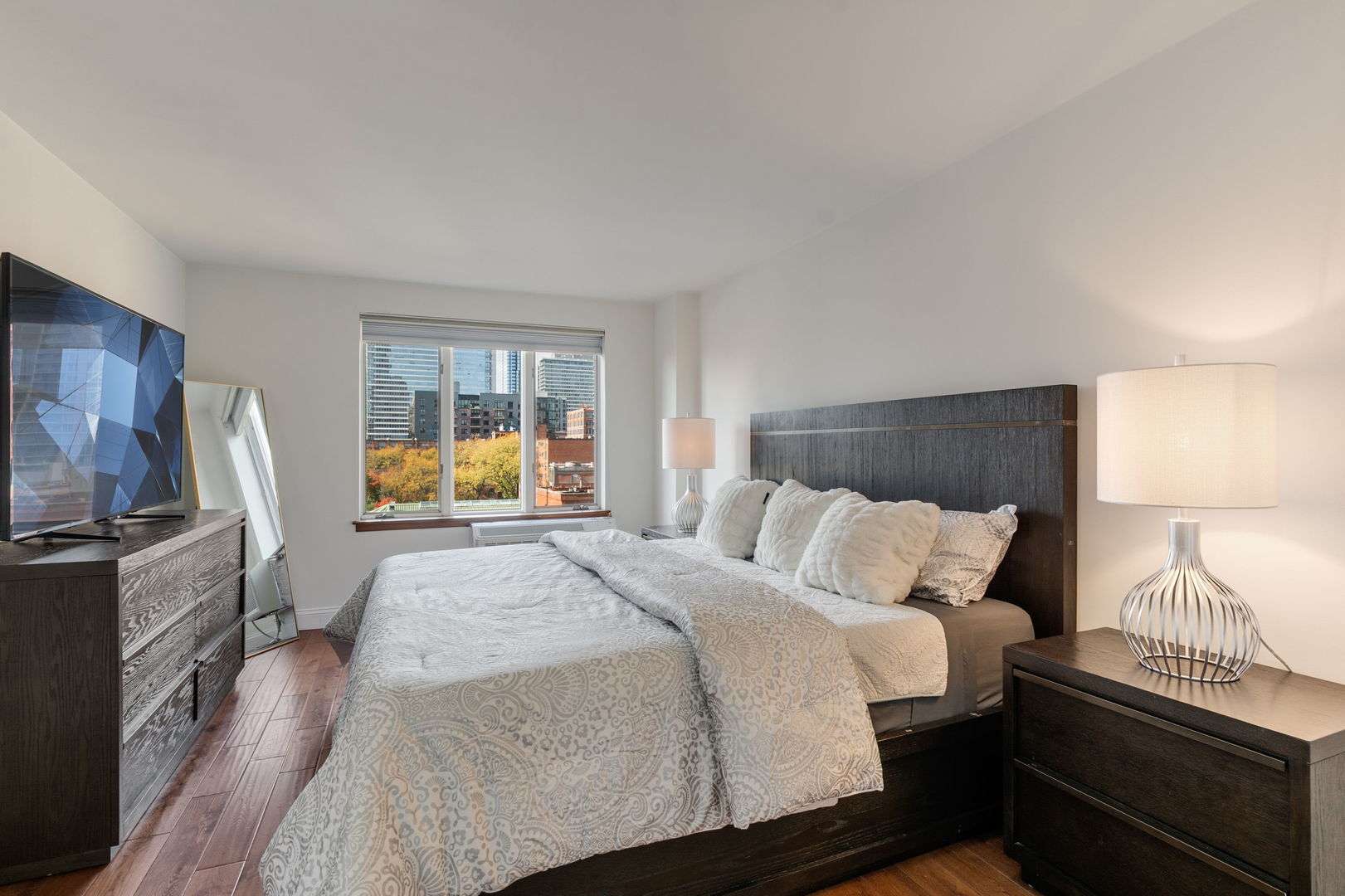 801 South Plymouth Court, Unit 602 Chicago, IL 60605 - Photo 10 of 15 a bedroom with a bed and a flat screen tv