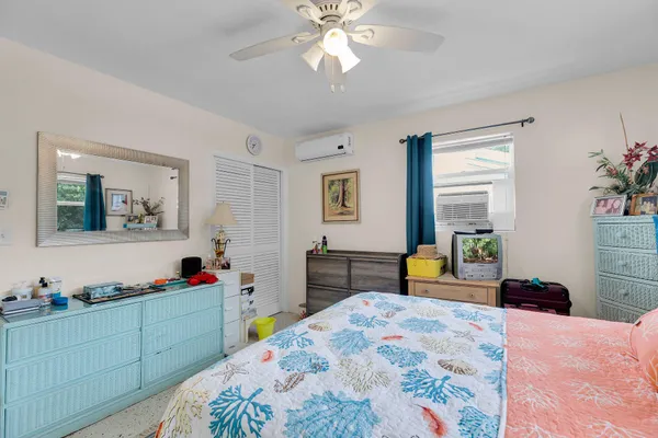 a view of a backyard with table and chairs potted plants and large tree