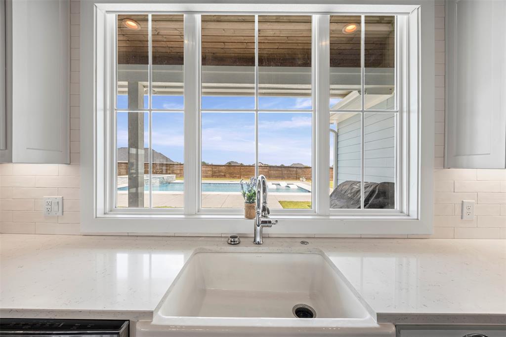 Kitchen view of decorative backsplash and light stone countertops