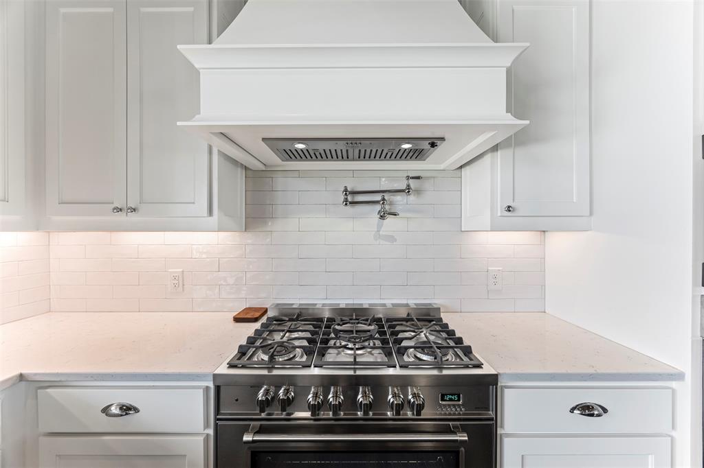 4421 Azalea Way Midlothian, TX 76065 - Photo 11 of 38 Kitchen with custom range hood, gas stove, light stone countertops, and white cabinetry
