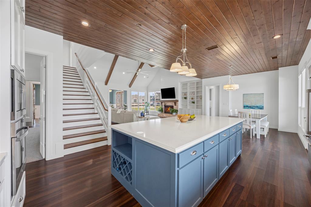 4421 Azalea Way Midlothian, TX 76065 - Photo 38 of 38 Kitchen featuring vaulted ceiling, blue cabinetry, open shelves, hanging light fixtures, and open floor plan