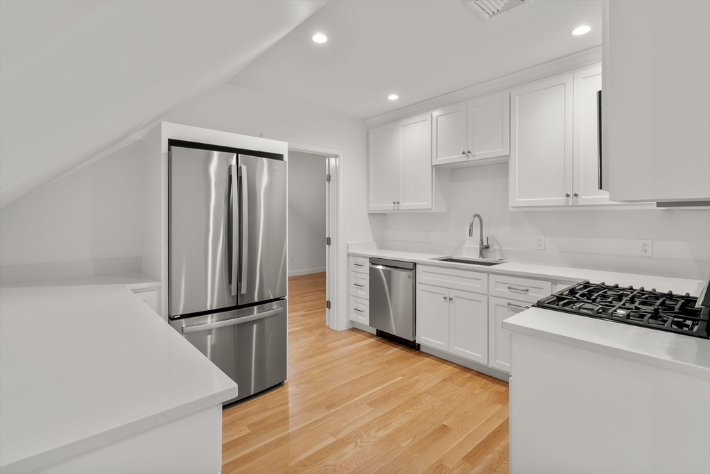 202 Washington Street, Unit A Wellesley, MA 02481 - Photo 4 of 9 a kitchen with stainless steel appliances granite countertop a refrigerator sink and white cabinets