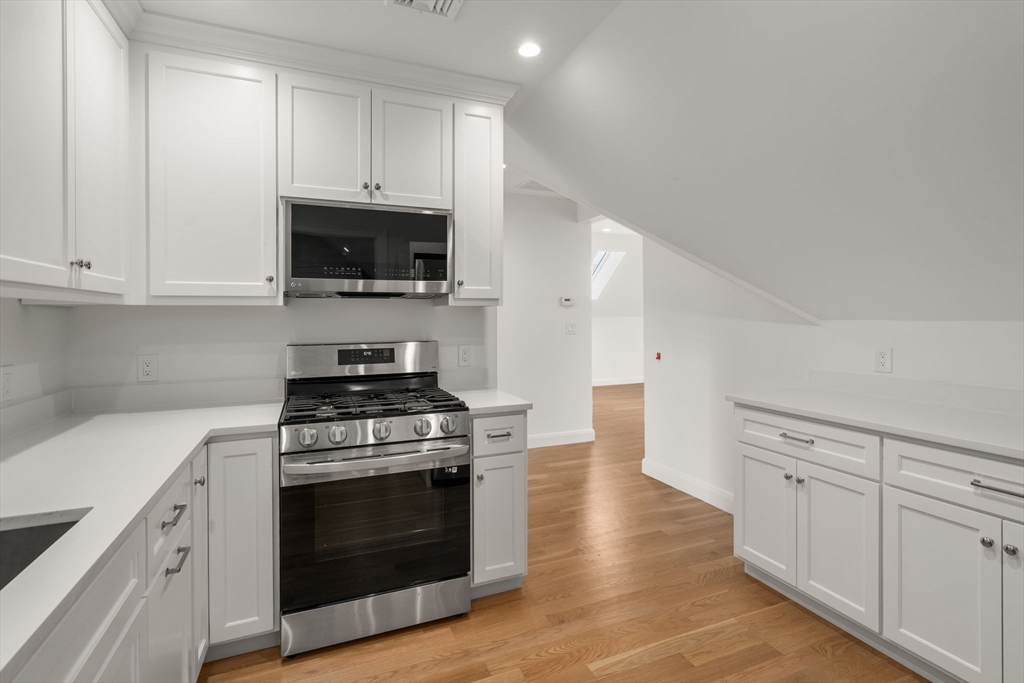 202 Washington Street, Unit A Wellesley, MA 02481 - Photo 5 of 9 a kitchen with white cabinets and appliances