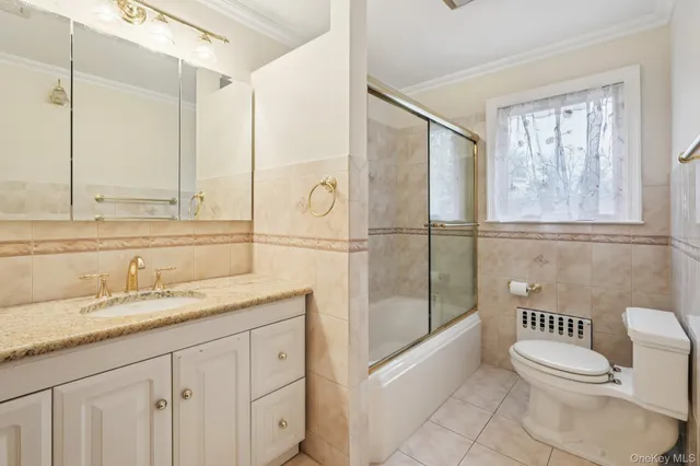 a bathroom with a granite countertop sink a toilet a mirror and shower