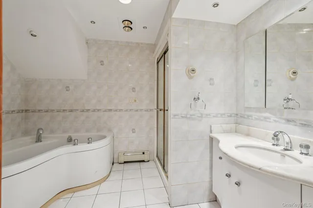 a bathroom with a granite countertop sink mirror and a bathtub