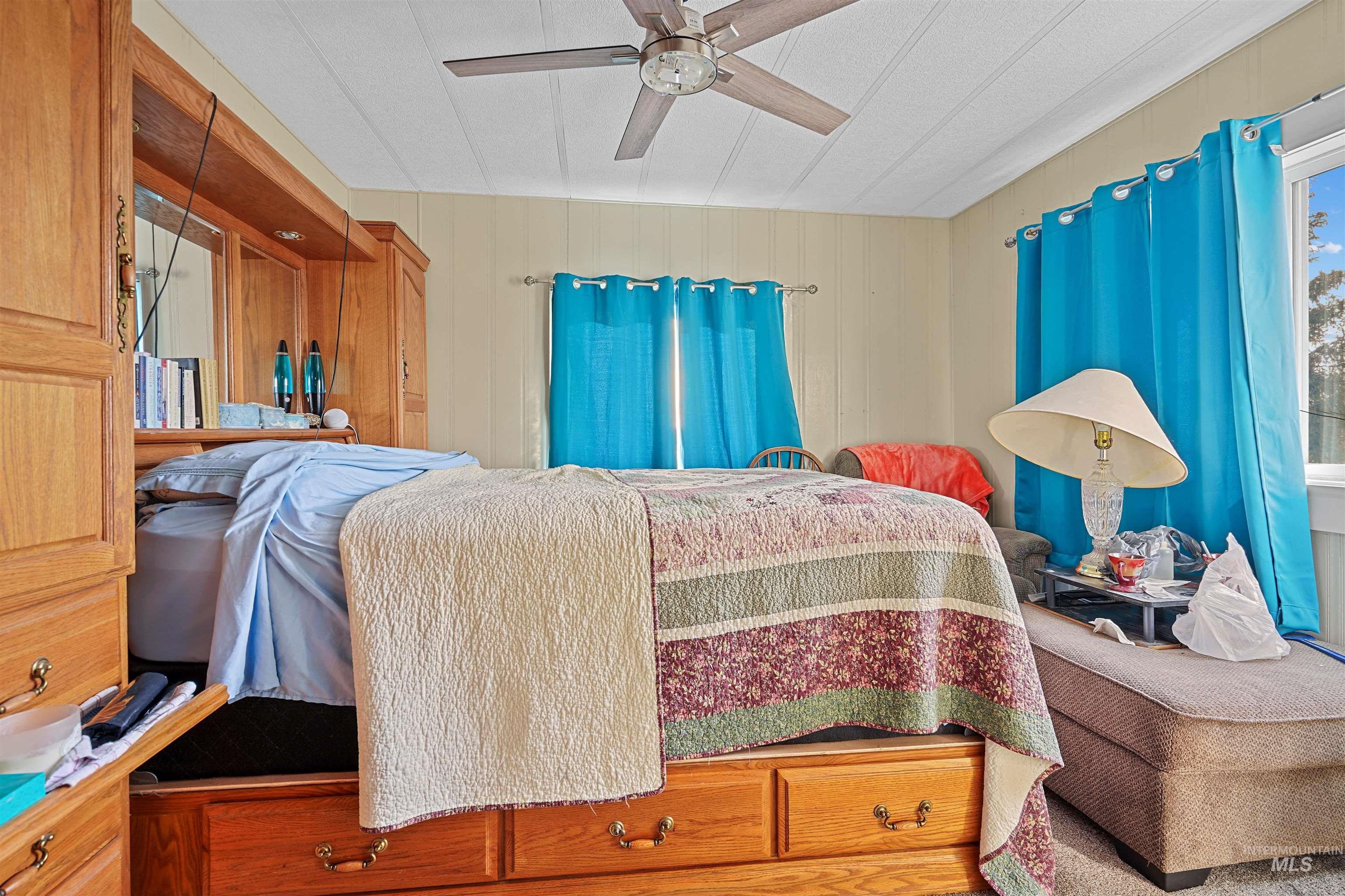 1176 East 600 North Rupert, ID 83350 - Photo 4 of 19 Bedroom with ceiling fan and wooden walls