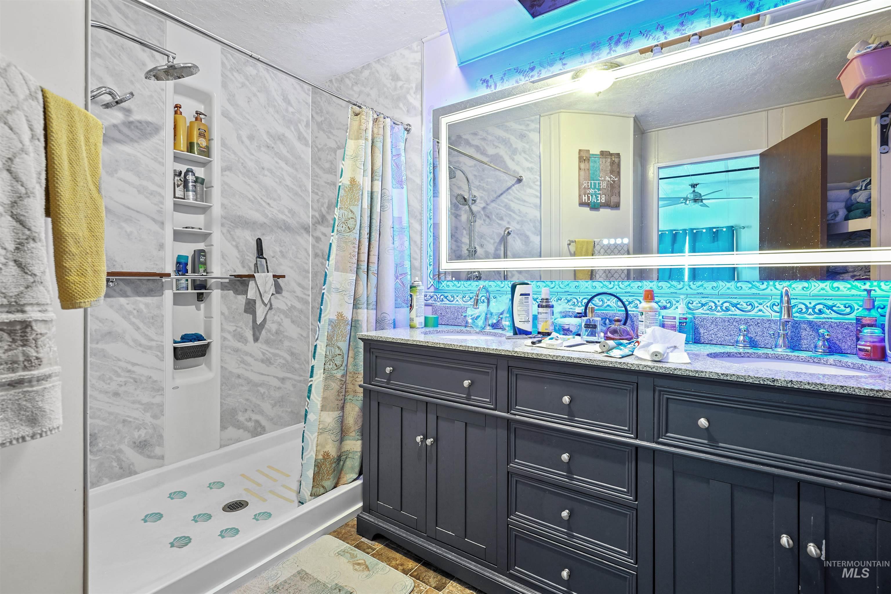 1176 East 600 North Rupert, ID 83350 - Photo 5 of 19 Bathroom with a shower stall, double vanity, and a textured ceiling