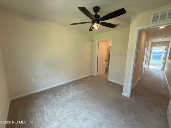 an empty room with a ceiling fan and a window