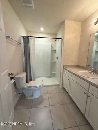 a bathroom with a granite countertop sink toilet a mirror and shower