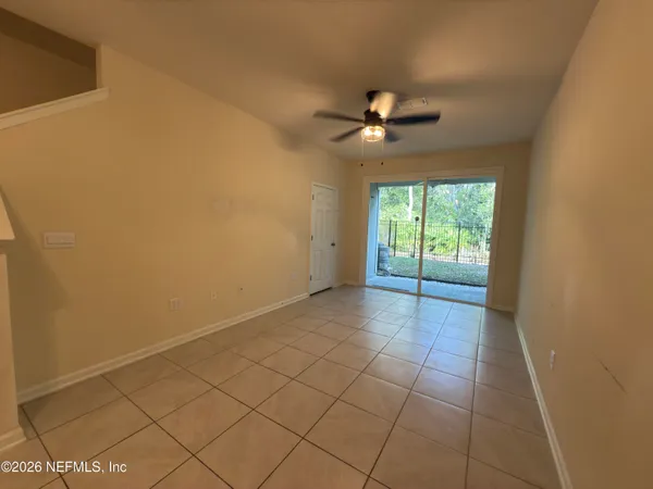 en empty room with windows and fan