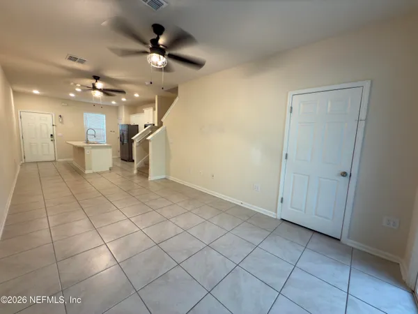 a view of an empty room and a ceiling fan