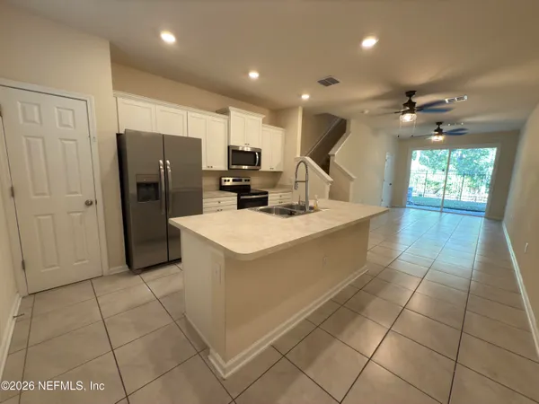 a kitchen with stainless steel appliances a refrigerator sink and cabinets
