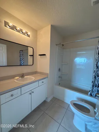 a spacious bathroom with a bathtub shower sink mirror and toilet