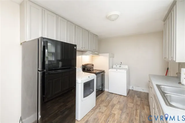 a kitchen with a refrigerator and a stove top oven