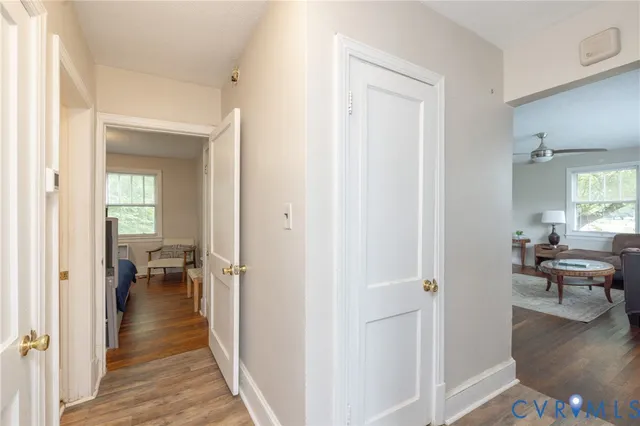 a view of a hallway with dining room and wooden floor