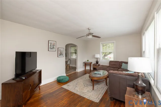 a living room with furniture a flat screen tv and a window