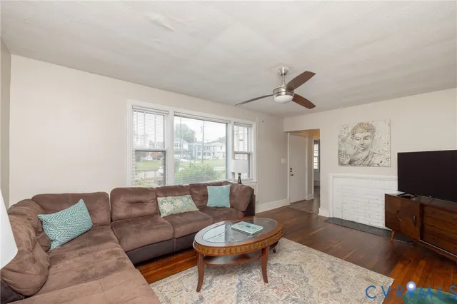 a living room with furniture a flat screen tv and a window