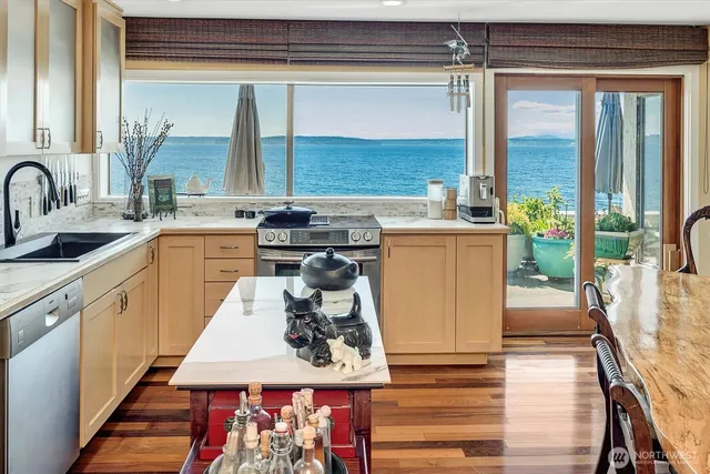 a living room with furniture kitchen view and a large window
