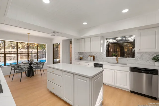 a large white kitchen with a large window
