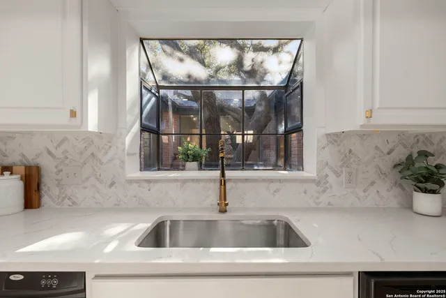 a kitchen with a sink and mirror