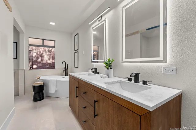 a bathroom with a sink double vanity granite and a bathtub