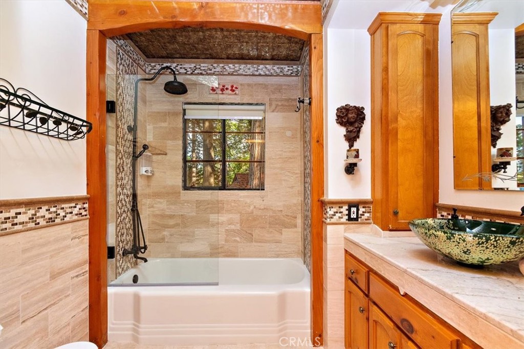329 Summit Road Lake Arrowhead, CA 92352 - Photo 30 of 61 a bathroom with a granite countertop sink a mirror and a bathtub