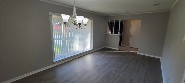 an empty room with a fireplace and chandelier