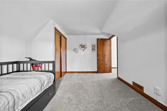 a bedroom with a bed and a painting on the wall