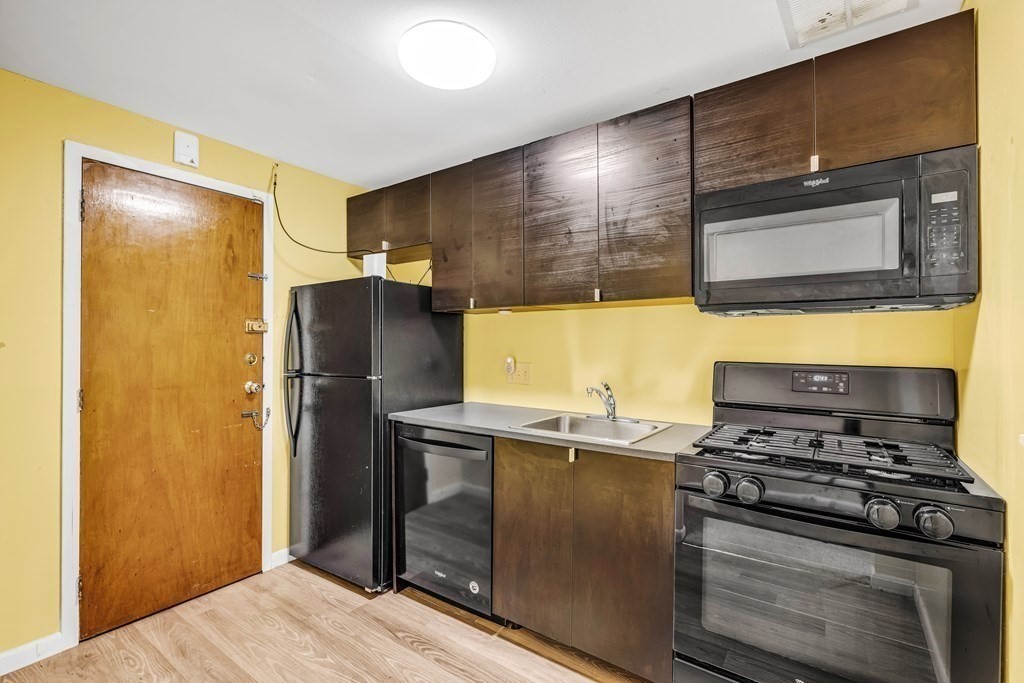 175 Clare Avenue, Unit E8 Boston, MA 02136 - Photo 4 of 16 a kitchen with a refrigerator and a stove top oven