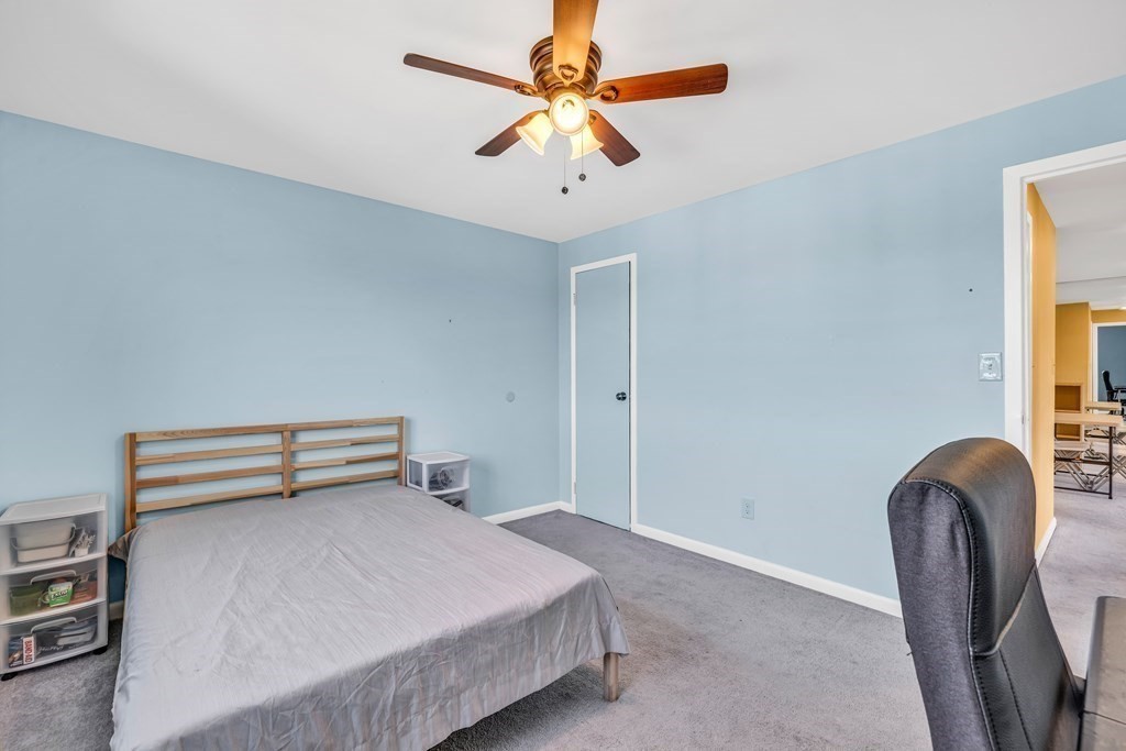 175 Clare Avenue, Unit E8 Boston, MA 02136 - Photo 8 of 16 a bedroom with a bed and a chandelier