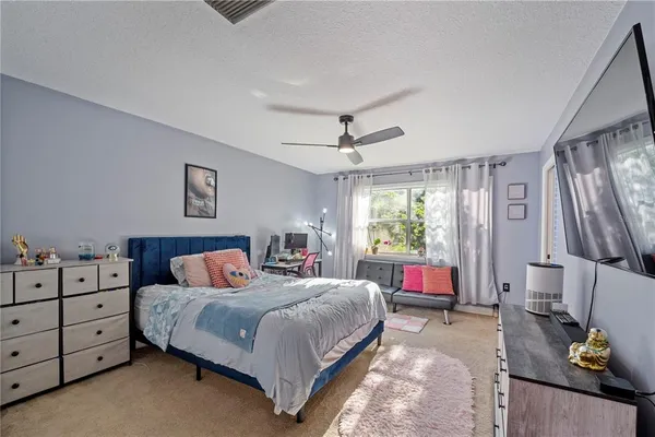 a bedroom with a large bed and a flat tv screen on dresser