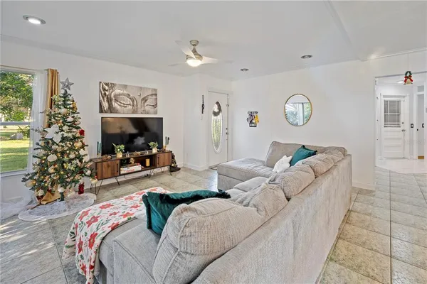 a living room with furniture a flat screen tv and a christmas tree