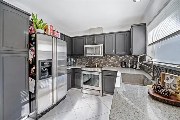 a kitchen with stainless steel appliances granite countertop a refrigerator and a stove