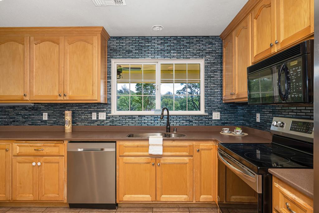6181 Lambert Lane El Dorado, CA 95623 - Photo 31 of 68 kitchen with stainless steel appliances, decorative backsplash, and dark countertops
