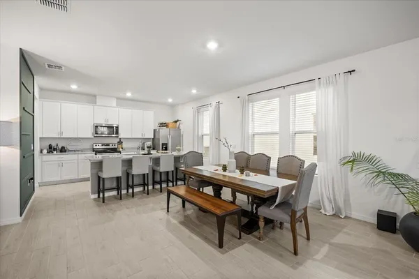 a dining room with furniture and a floor to ceiling window