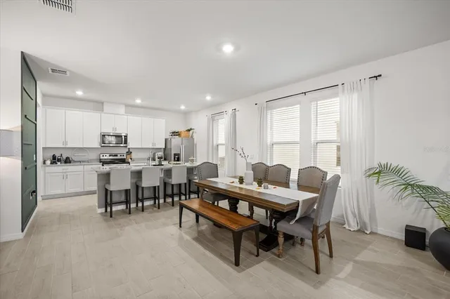 a dining room with furniture and a floor to ceiling window