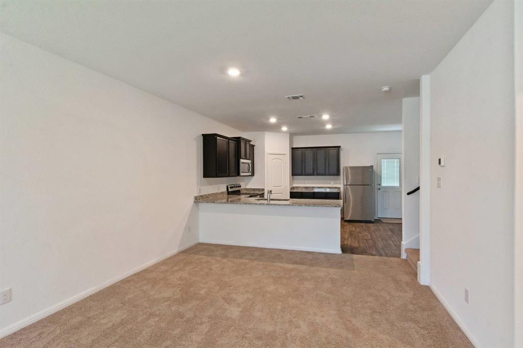 16429 Farmhouse Lane Elgin, TX 78621 - Photo 4 of 22 Open-concept living area with neutral carpet flooring and recessed lighting