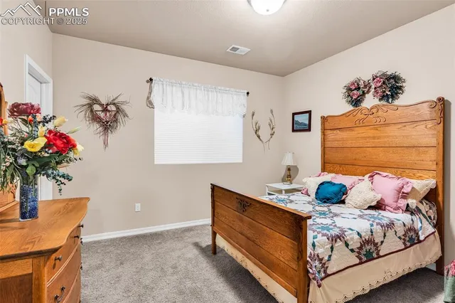 a bedroom with a bed potted plant on dresser and a window