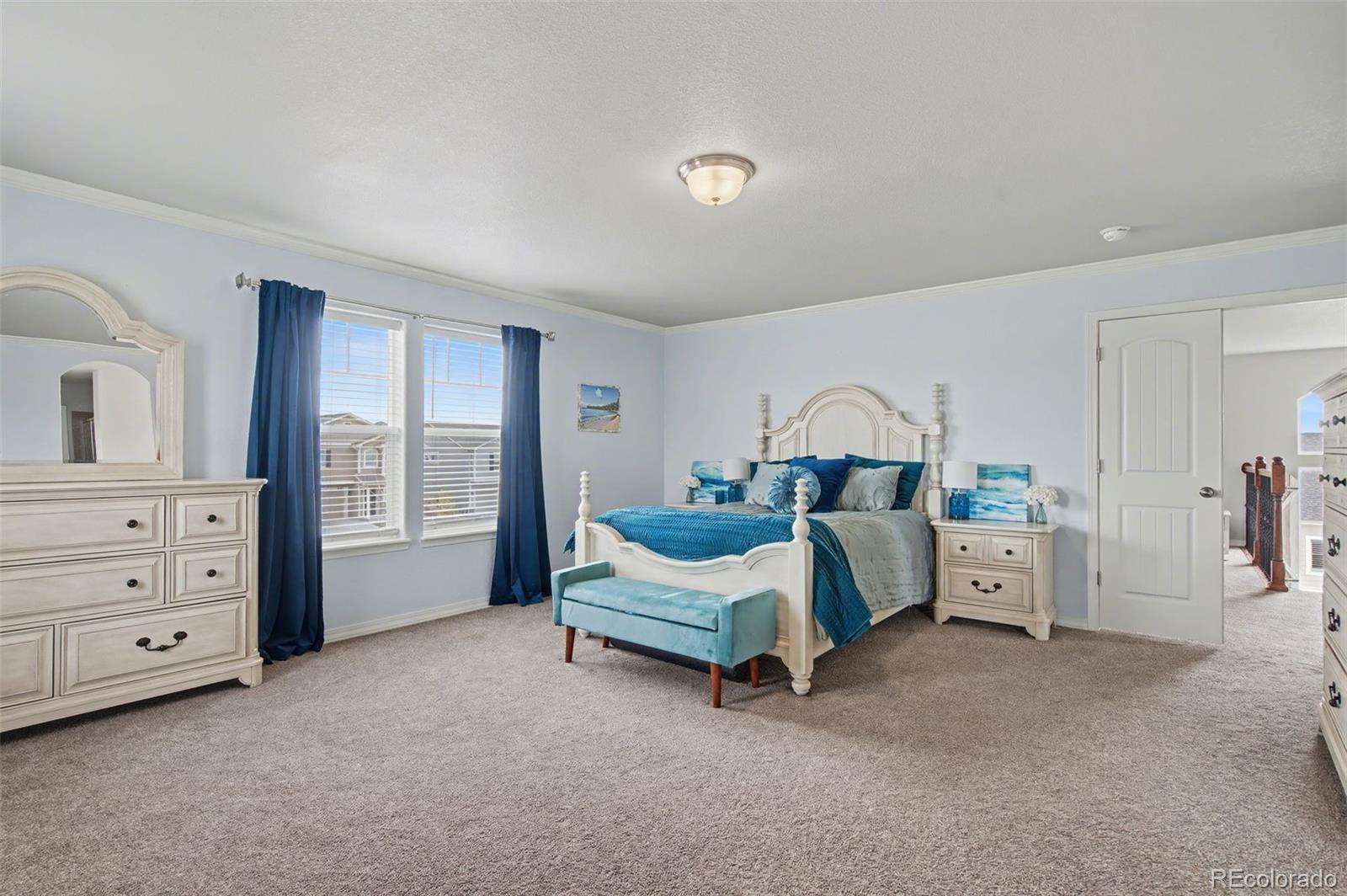 8271 White Fish Way Colorado Springs, CO 80908 - Photo 16 of 47 a spacious bedroom with a bed and a chair