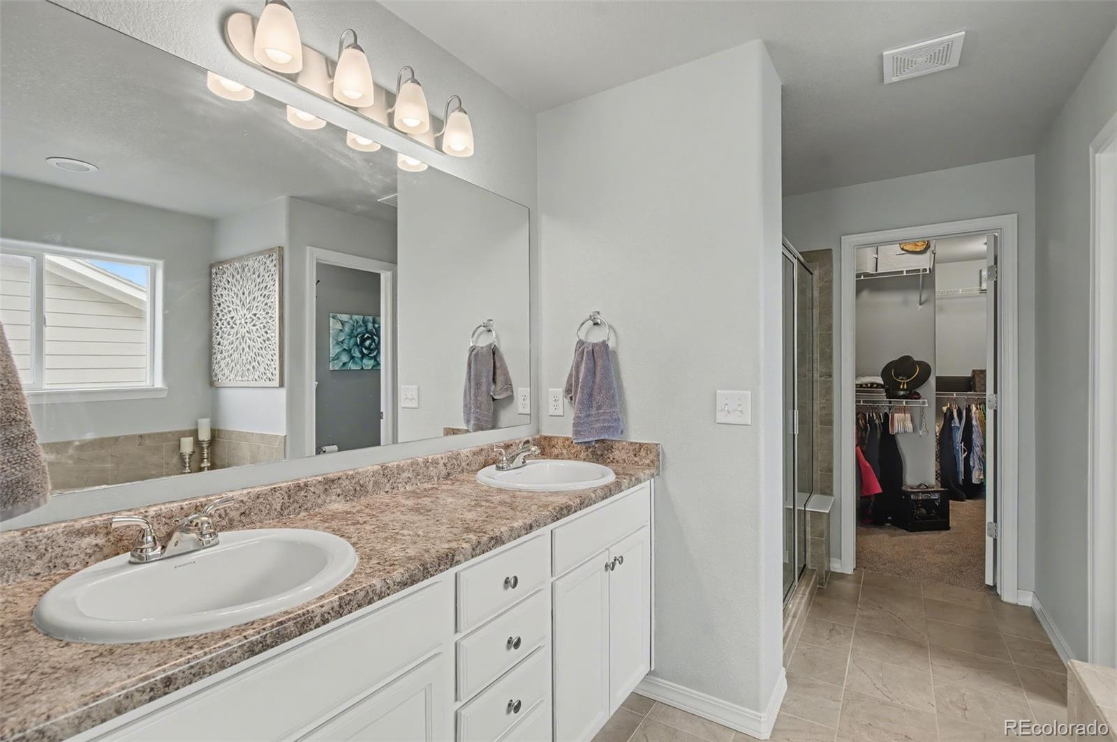 8271 White Fish Way Colorado Springs, CO 80908 - Photo 19 of 47 a bathroom with a granite countertop sink and a mirror