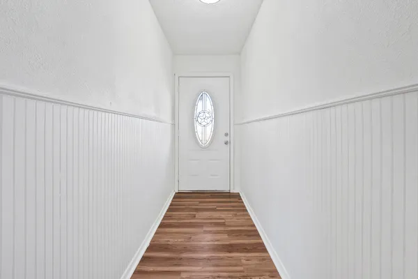 a view of a hallway with wooden floor