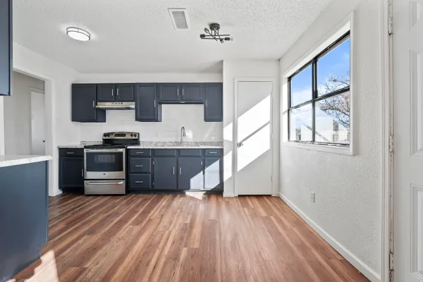 a kitchen with stainless steel appliances granite countertop a stove a sink and a refrigerator