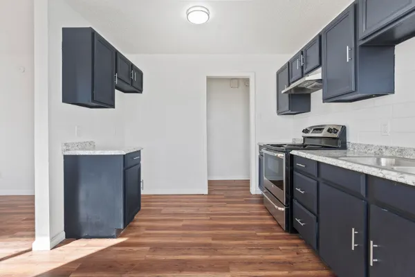a kitchen with stainless steel appliances granite countertop a sink stove and microwave