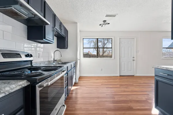 a kitchen with stainless steel appliances granite countertop a stove and a sink